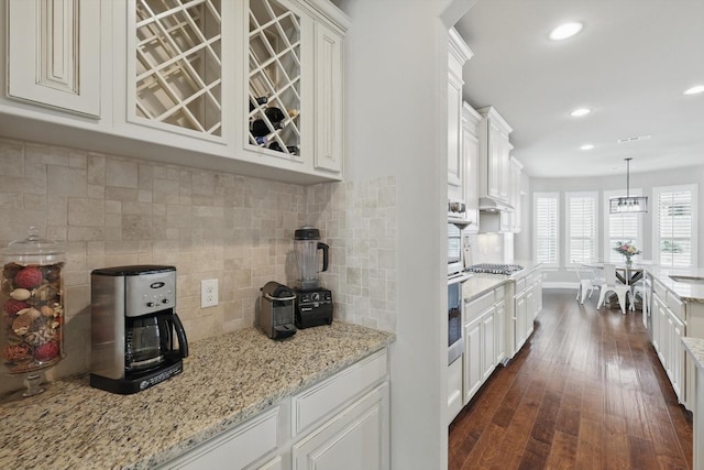 kitchen with white cabinets, appliances with stainless steel finishes, and dark wood-style flooring