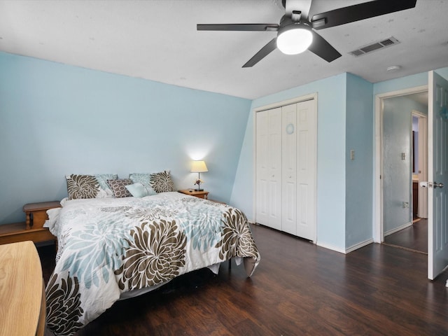 bedroom with a closet, visible vents, baseboards, ceiling fan, and wood finished floors