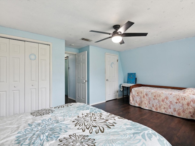 bedroom with baseboards, ceiling fan, visible vents, and wood finished floors