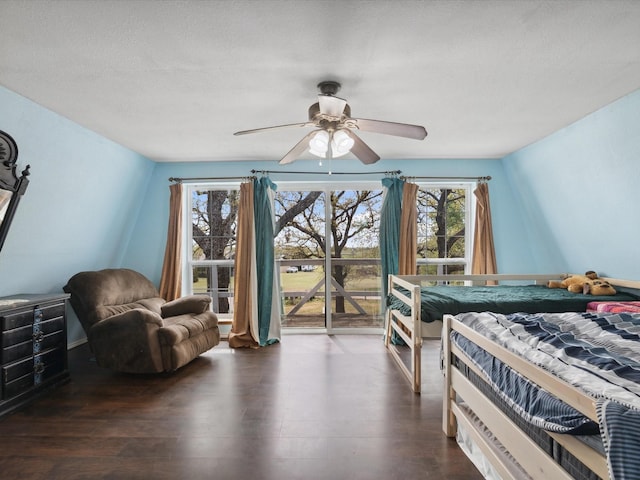 bedroom with dark wood-type flooring, access to exterior, and multiple windows