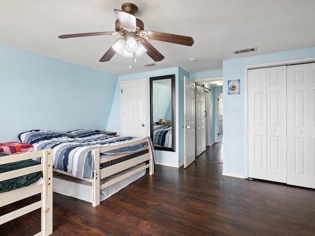 bedroom featuring baseboards, ceiling fan, visible vents, and wood finished floors