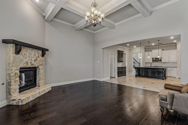 1596 Mannheim Dr, Rockwall, TX 75032 - living room with a notable chandelier, a fireplace, arched walkways, beamed ceiling, and coffered ceiling