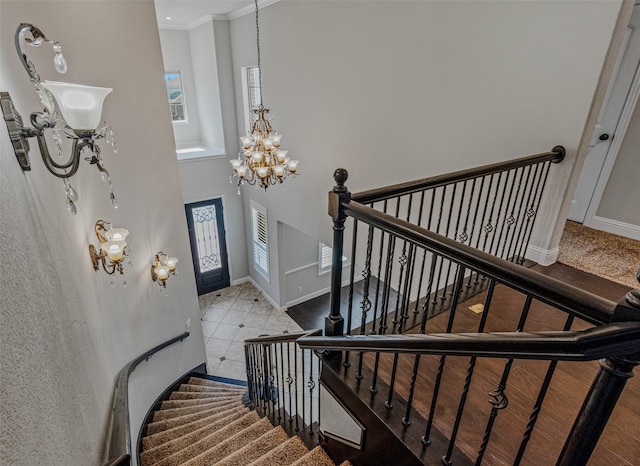 1596 Mannheim Dr, Rockwall, TX 75032 - staircase with a high ceiling, baseboards, tile patterned floors, a chandelier, and ornamental molding