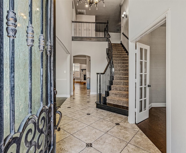 1596 Mannheim Dr, Rockwall, TX 75032 - entrance foyer featuring arched walkways, tile patterned floors, stairs, baseboards, and a towering ceiling