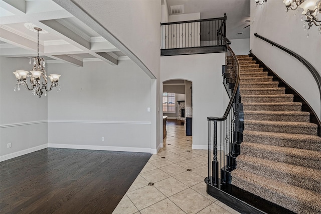 1596 Mannheim Dr, Rockwall, TX 75032 - entrance foyer with crown molding, arched walkways, a chandelier, beamed ceiling, and stairway