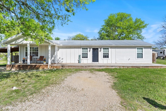 view of front of home featuring a front lawn, metal roof, and covered porch