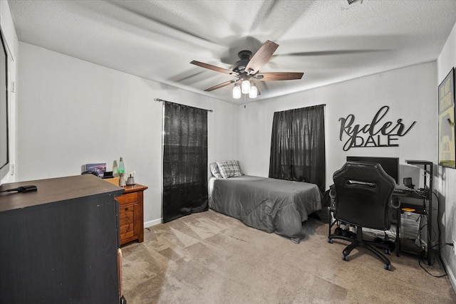 bedroom featuring light colored carpet, a ceiling fan, and a textured ceiling