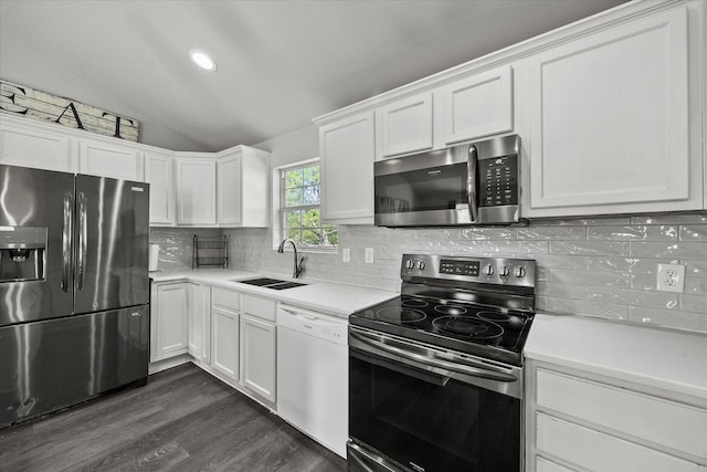 kitchen with light countertops, a sink, appliances with stainless steel finishes, lofted ceiling, and white cabinets