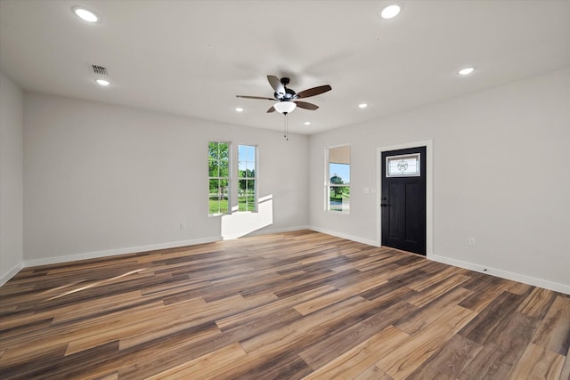 unfurnished room with wood finished floors, a ceiling fan, recessed lighting, and baseboards