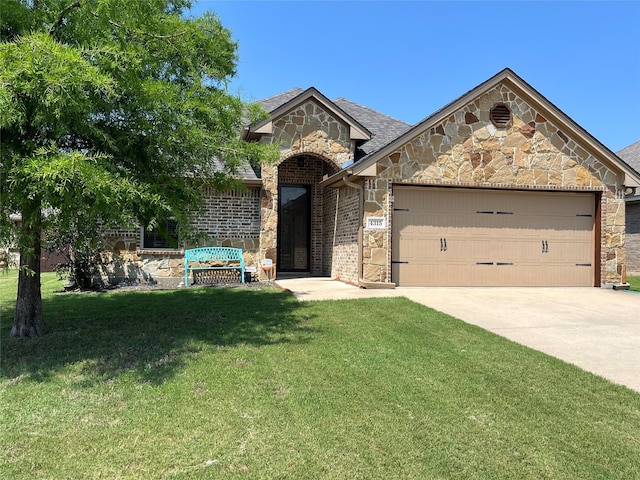4315 Logan Cir, Granbury, TX 76049 - french country home with stone siding, an attached garage, a front lawn, concrete driveway, and brick siding