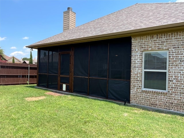 4315 Logan Cir, Granbury, TX 76049 - rear view of property featuring roof with shingles, brick siding, a chimney, and a sunroom
