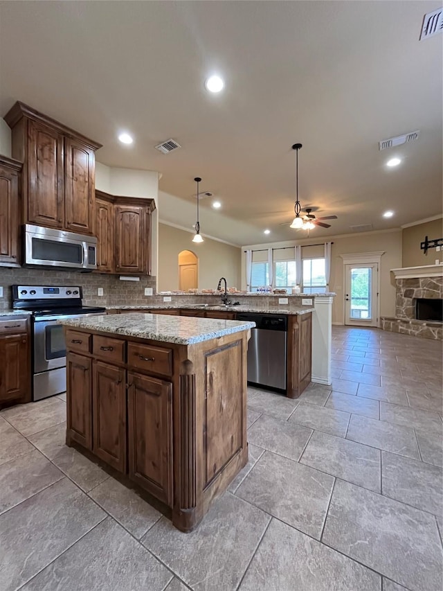 4315 Logan Cir, Granbury, TX 76049 - kitchen with stainless steel appliances, ceiling fan, decorative backsplash, open floor plan, and crown molding