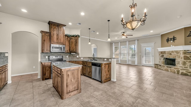 4315 Logan Cir, Granbury, TX 76049 - kitchen with stainless steel appliances, arched walkways, a ceiling fan, open floor plan, and a peninsula