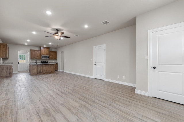 2685 Thompson Rd, Weatherford, TX 76087 - unfurnished living room featuring arched walkways, ceiling fan, recessed lighting, baseboards, and light wood-style floors