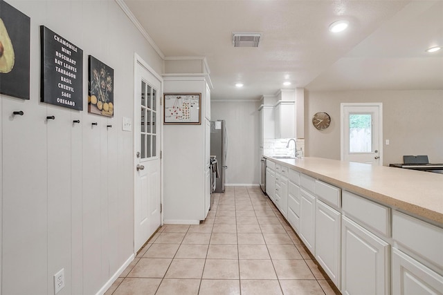 136 NW Suzanne Ter, Burleson, TX 76028 - kitchen with a sink, white cabinets, ornamental molding, light countertops, and light tile patterned floors