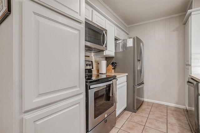 136 NW Suzanne Ter, Burleson, TX 76028 - kitchen featuring appliances with stainless steel finishes, crown molding, white cabinetry, light tile patterned floors, and light countertops
