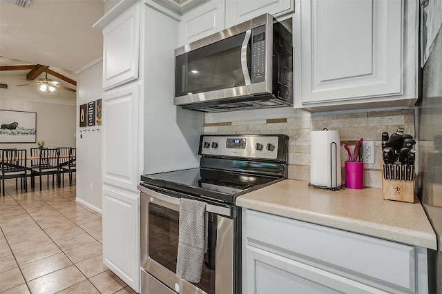 136 NW Suzanne Ter, Burleson, TX 76028 - kitchen featuring appliances with stainless steel finishes, light tile patterned floors, tasteful backsplash, white cabinets, and crown molding