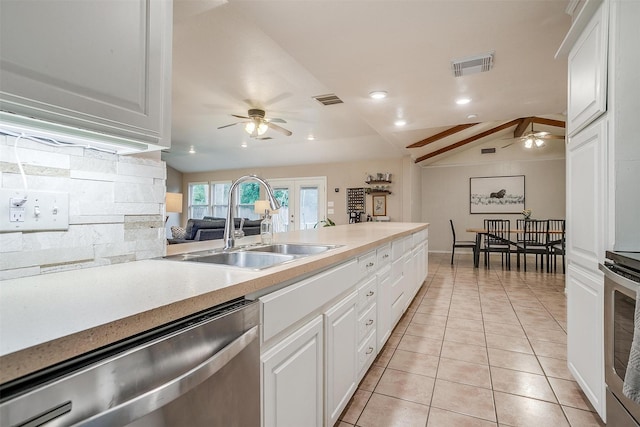 136 NW Suzanne Ter, Burleson, TX 76028 - kitchen featuring stainless steel dishwasher, ceiling fan, a sink, white cabinetry, and lofted ceiling