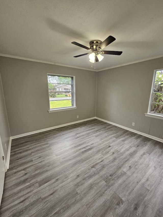 unfurnished room with a ceiling fan, plenty of natural light, crown molding, and wood finished floors
