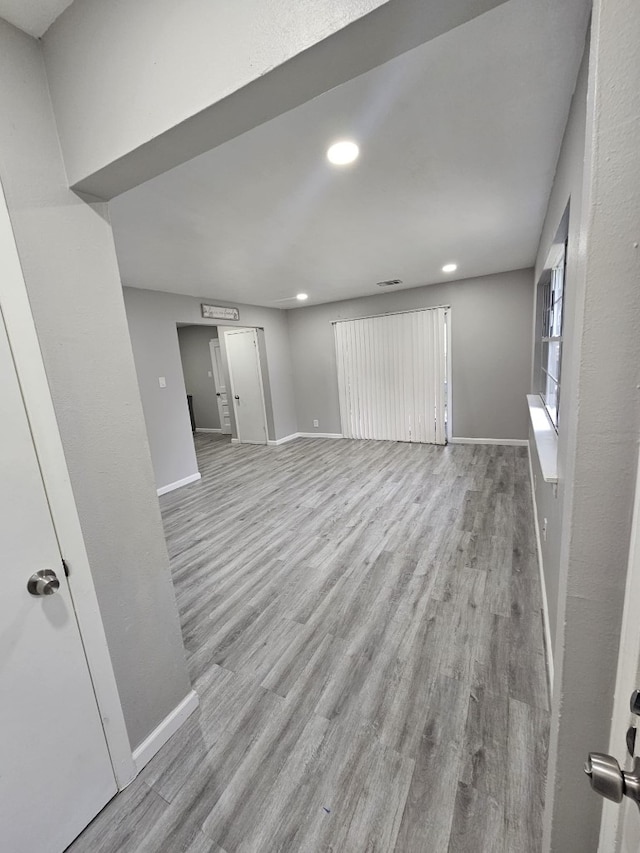 interior space featuring baseboards, visible vents, wood finished floors, and recessed lighting