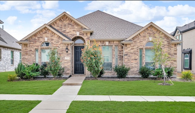 1125 Overton St, Frisco, TX 75036 - french provincial home featuring a front yard, brick siding, and a shingled roof