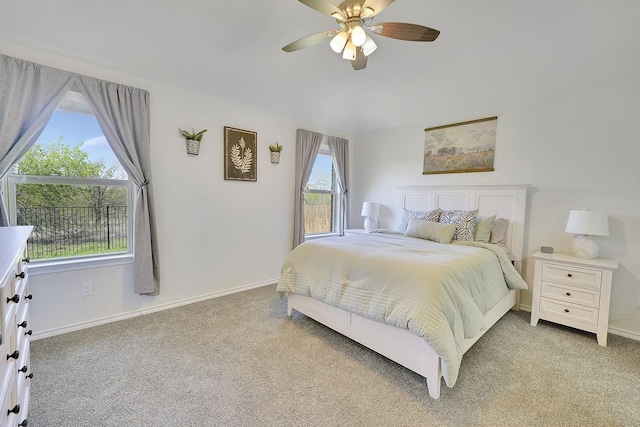 bedroom with light colored carpet, baseboards, and ceiling fan