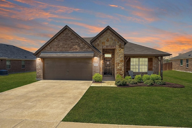 french country style house featuring brick siding, an attached garage, a lawn, and driveway