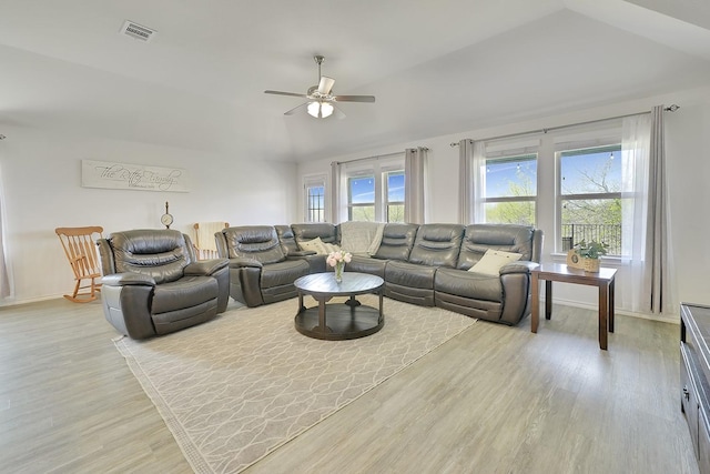 living area with vaulted ceiling, a ceiling fan, light wood-style floors, and baseboards