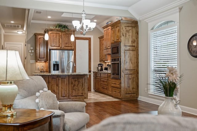 kitchen with light stone counters, light wood-type flooring, visible vents, and stainless steel appliances