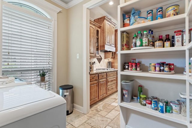 interior space featuring stone tile floors, baseboards, laundry area, and crown molding