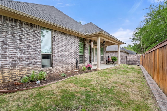 view of yard with a fenced backyard, a ceiling fan, and a patio