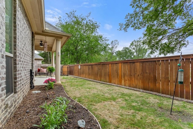 view of yard featuring a ceiling fan, a patio, and a fenced backyard