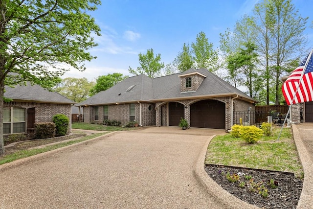 french country home featuring an attached garage, fence, and aphalt driveway
