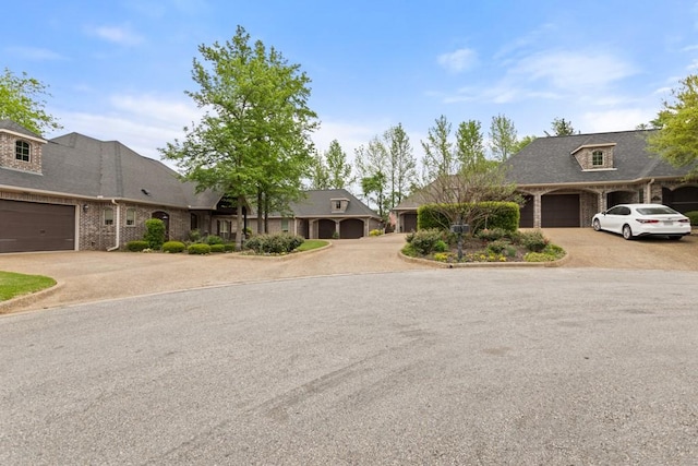 view of front of home with brick siding, an attached garage, and aphalt driveway
