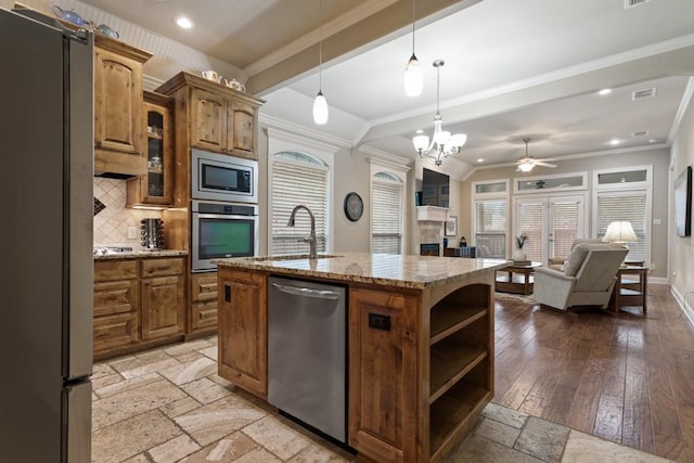 kitchen featuring brown cabinetry, visible vents, appliances with stainless steel finishes, and a sink
