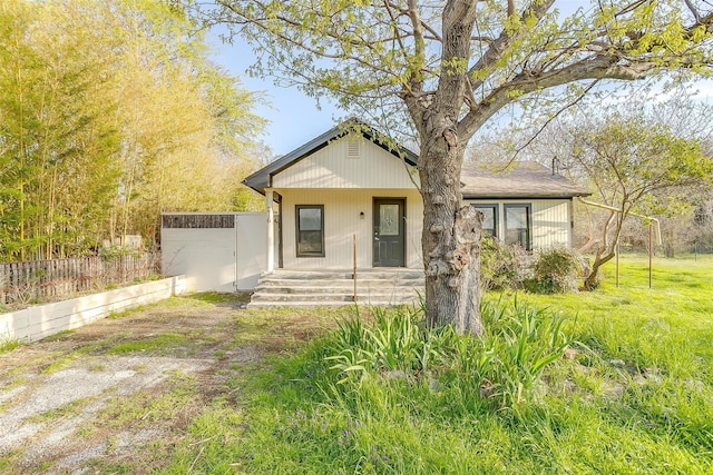 bungalow-style house featuring covered porch and fence