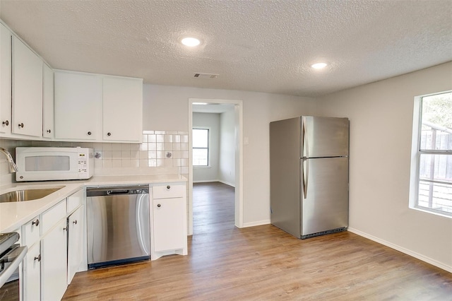 kitchen featuring visible vents, light countertops, light wood-style floors, and stainless steel appliances