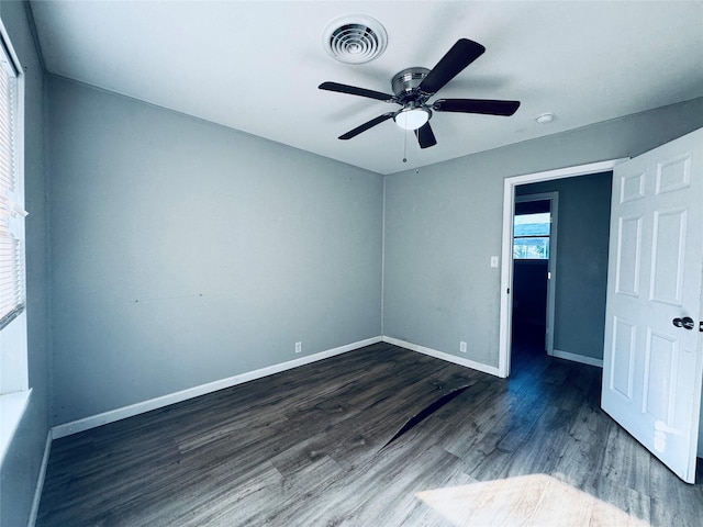 unfurnished bedroom featuring wood finished floors, baseboards, a ceiling fan, and visible vents