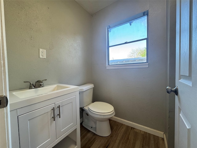 bathroom with vanity, baseboards, toilet, and wood finished floors