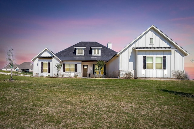 modern farmhouse style home with a yard, board and batten siding, and a shingled roof