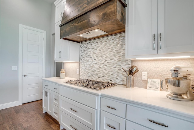 kitchen with tasteful backsplash, white cabinetry, stainless steel gas cooktop, and extractor fan