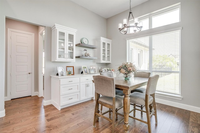 dining area featuring a chandelier, baseboards, and light wood-style flooring