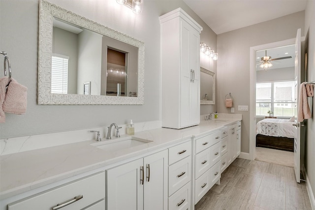 ensuite bathroom with double vanity, a sink, a ceiling fan, and ensuite bath