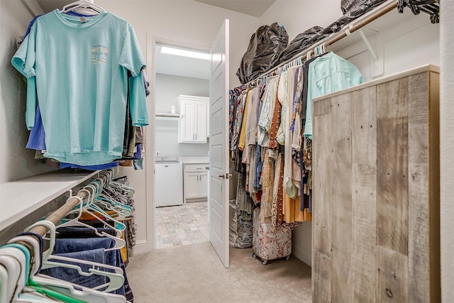 walk in closet featuring light colored carpet