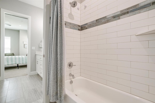 ensuite bathroom featuring shower / bath combo, ensuite bathroom, baseboards, and vanity