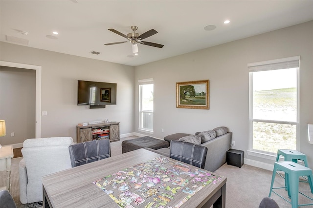 carpeted dining area with visible vents, ceiling fan, plenty of natural light, and baseboards