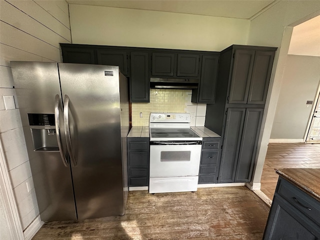 301 E White St, Pilot Point, TX 76258 - kitchen with stainless steel fridge, white electric stove, under cabinet range hood, dark wood-type flooring, and tasteful backsplash