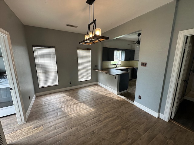 301 E White St, Pilot Point, TX 76258 - kitchen with wood finished floors, ceiling fan, a sink, and a peninsula