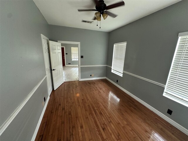 301 E White St, Pilot Point, TX 76258 - unfurnished bedroom featuring dark wood-style flooring, baseboards, and ceiling fan