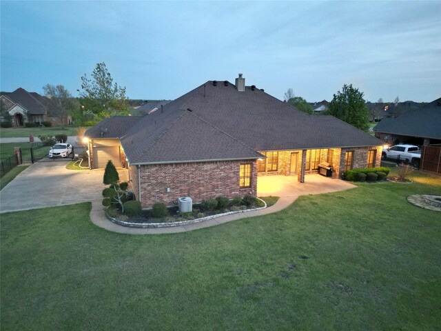 13111 Saint Orlin Way, Talty, TX 75126 - rear view of property with brick siding, concrete driveway, a chimney, a shingled roof, and cooling unit